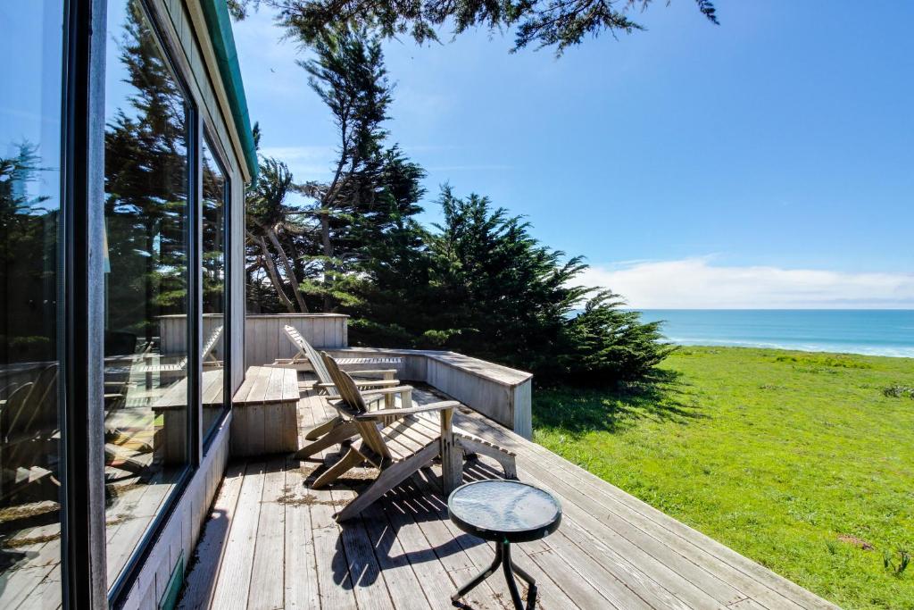 a porch with a bench and a view of the ocean at Bowsprit Retreat in Sea Ranch