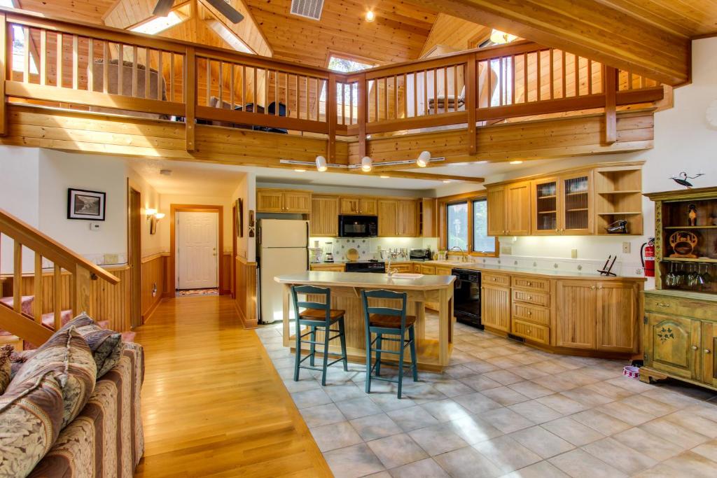 a large kitchen with wooden cabinets and a table at Harrison Loft in Cannon Beach