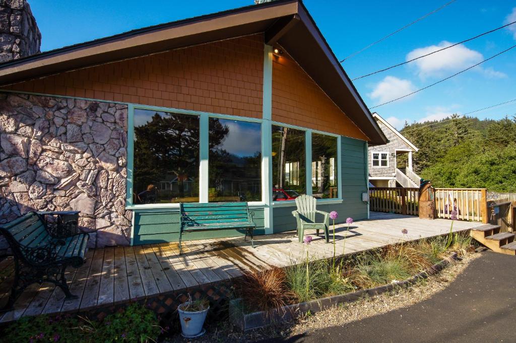 a house with a bench on a deck at Darrs Beach Cottage in Neskowin