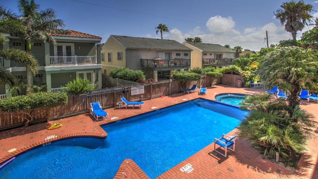 una vista aérea de una piscina con sillas azules y palmeras en Ventura Condominiums #204, en South Padre Island