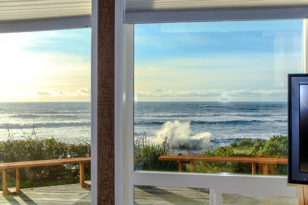 una casa de playa con vistas al océano desde la ventana en Harbor House, en Brookings