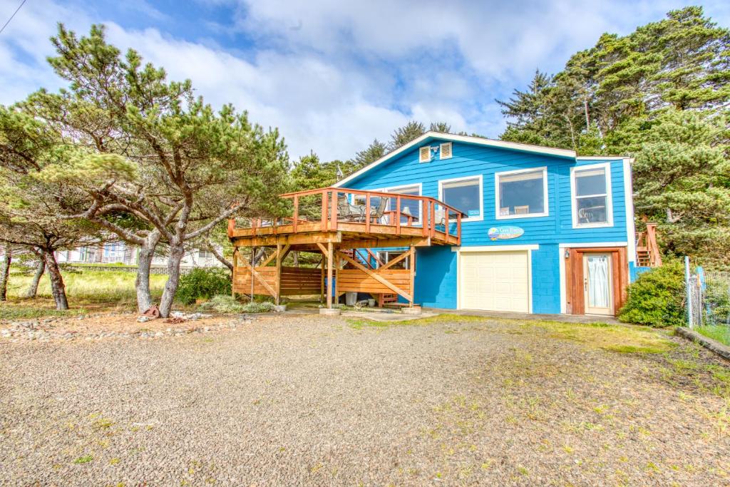 ein blaues Haus mit einer Veranda und einer Terrasse in der Unterkunft Casa Blanca del Mar in Waldport