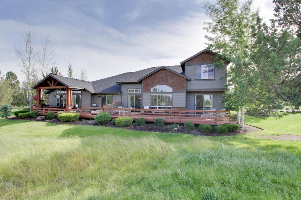 ein großes Haus mit einer großen Terrasse auf einem Rasen in der Unterkunft Eagle Crest's Tenth Green Villa in Redmond