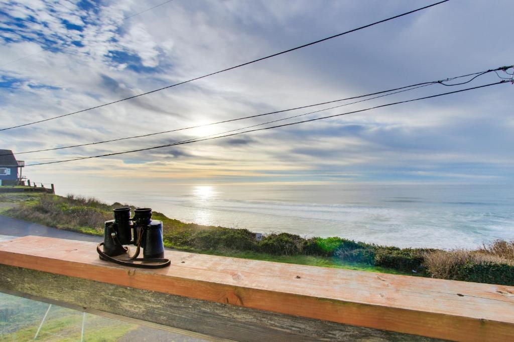 a pair of binoculars sitting on a ledge overlooking the ocean at Anchor Court Views in Lincoln City