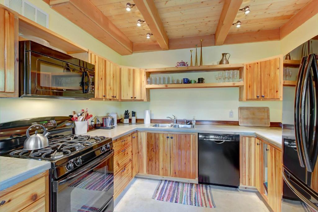 a kitchen with wooden cabinets and a stove top oven at The Osprey Perch in Garfield