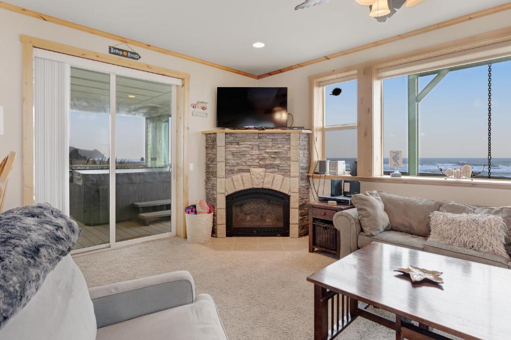 a living room with a fireplace and a tv at Sunset Beach House in Gold Beach