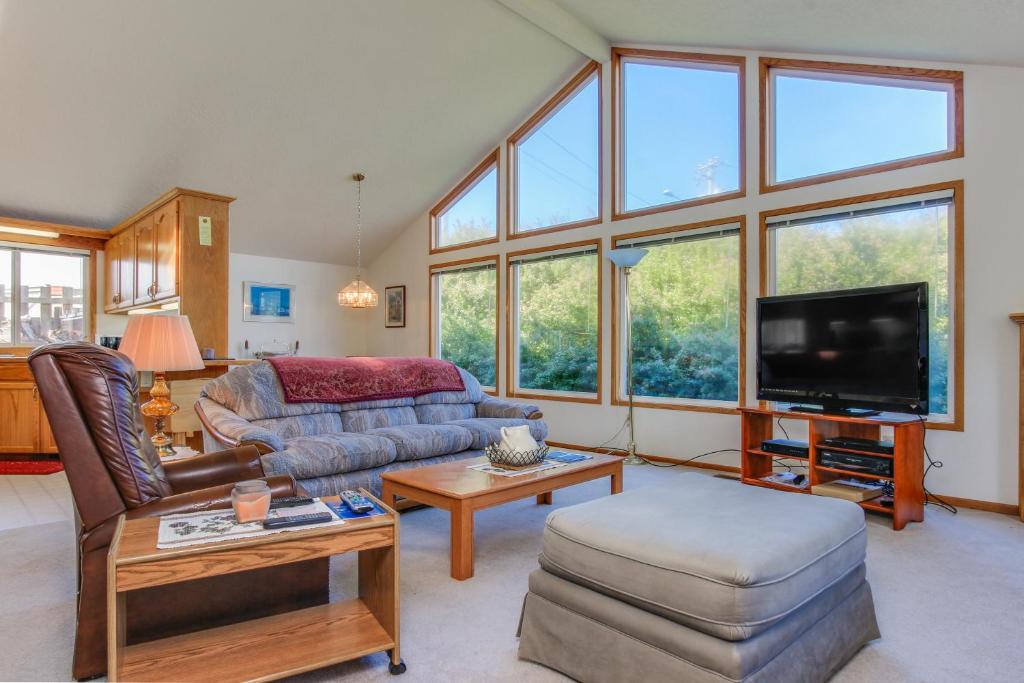 ein Wohnzimmer mit einem Sofa und einem TV in der Unterkunft Captain Bill's Beachhouse in Lincoln City