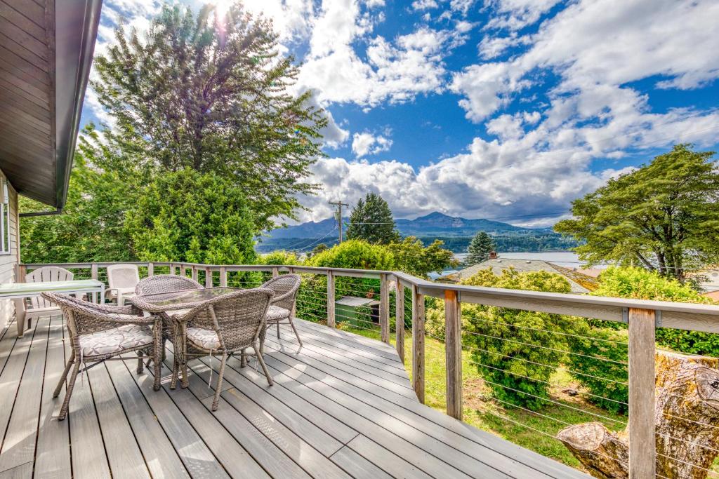 a patio with a table and chairs on a deck at Cascade River Watch in Cascade Locks