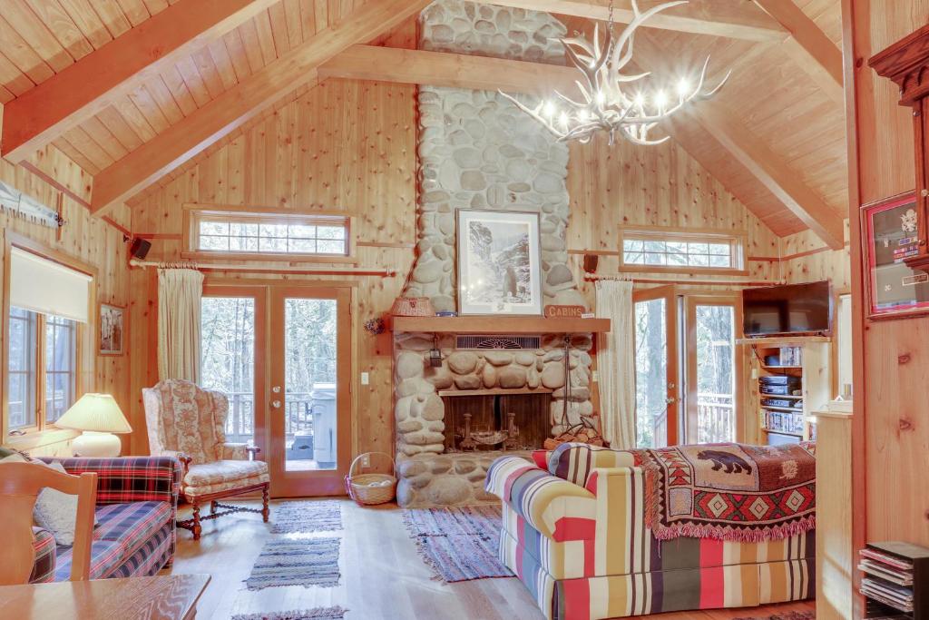 a living room with a stone fireplace in a cabin at Papa Bear Cabin in Welches