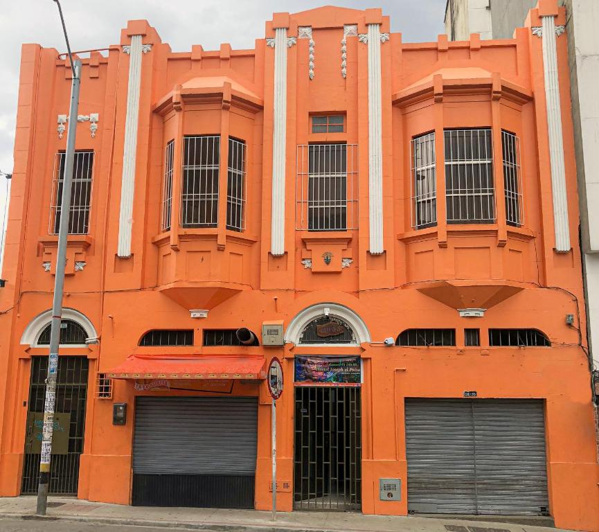 an orange building with two garage doors in front of it at JEP Hostel in Medellín