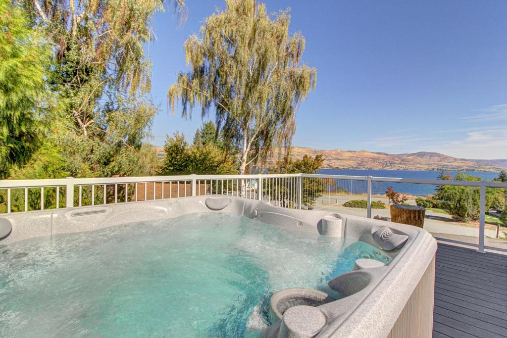 a hot tub on a deck with a view of the water at Royal View on Lakeshore in Chelan