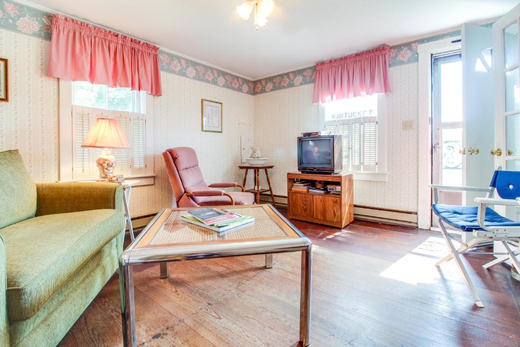 uma sala de estar com um sofá e uma televisão em The Rose Cottage em Nantucket
