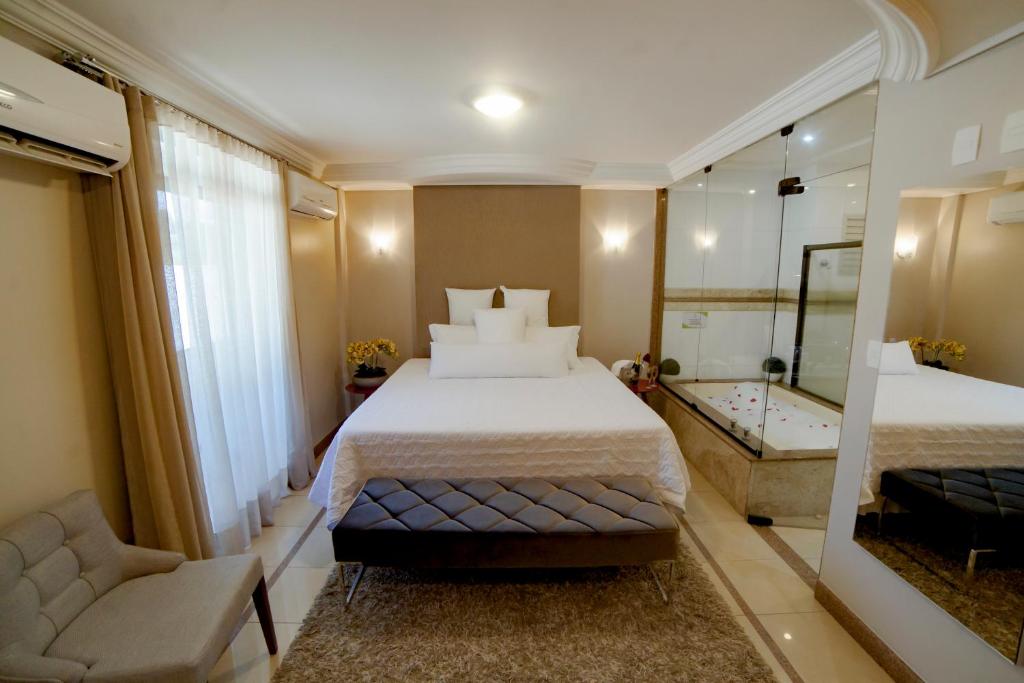 a hotel room with two beds and a mirror at Hotel Capital Das Pedras in Teófilo Otoni