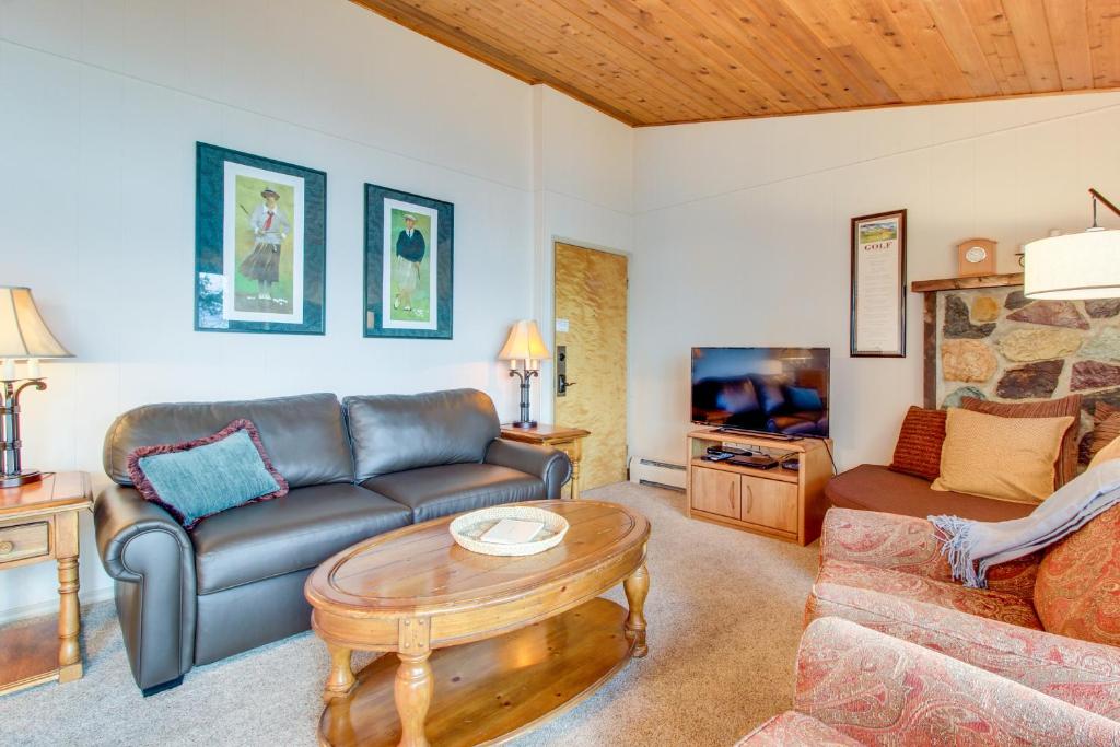 sala de estar con sofá y mesa en Bay Point Lakefront 1B Up, en Whitefish