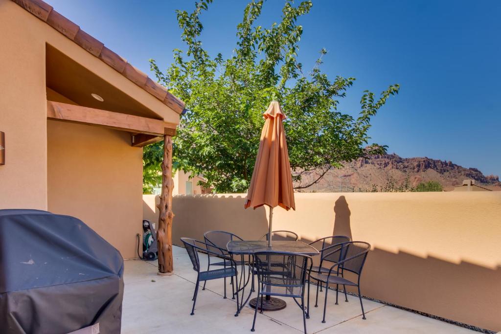 a patio with a table and chairs and an umbrella at Rim Village Q4 in Moab