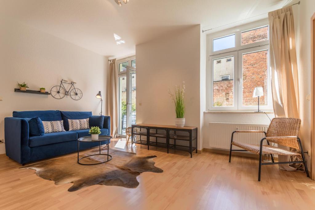 a living room with a blue couch and a table at Perle der Südvorstadt in Leipzig