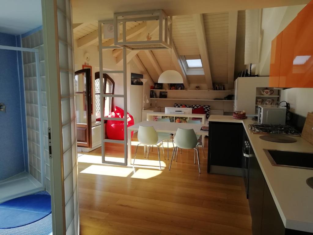Una cocina con una mesa y sillas en una habitación. en Mansarda Del Sole, Nel Cuore Di Aosta, en Aosta