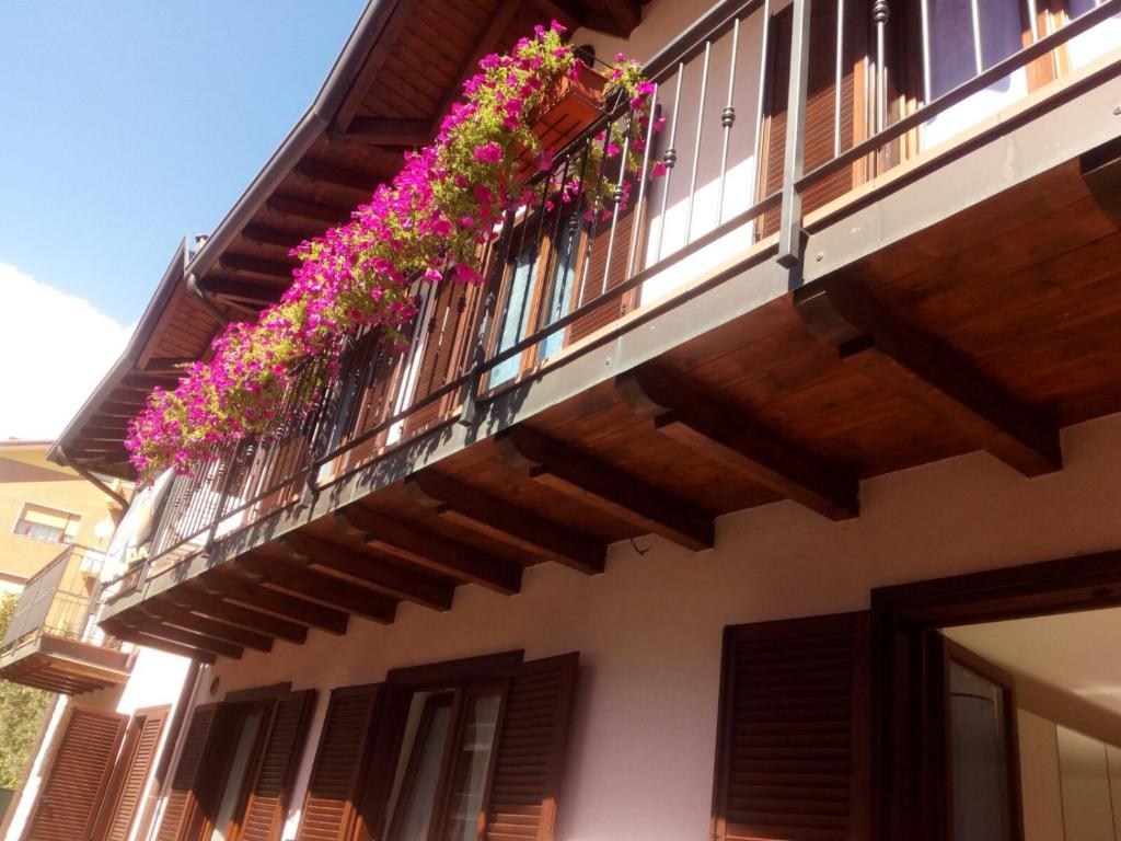 - un balcon avec des fleurs roses dans un bâtiment dans l'établissement Casa Tiziana, à Sovere