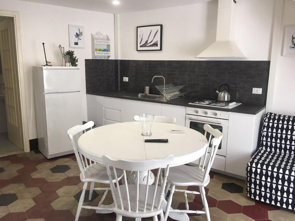 a kitchen with a white table and chairs in a room at a casa del reuccio in Catania
