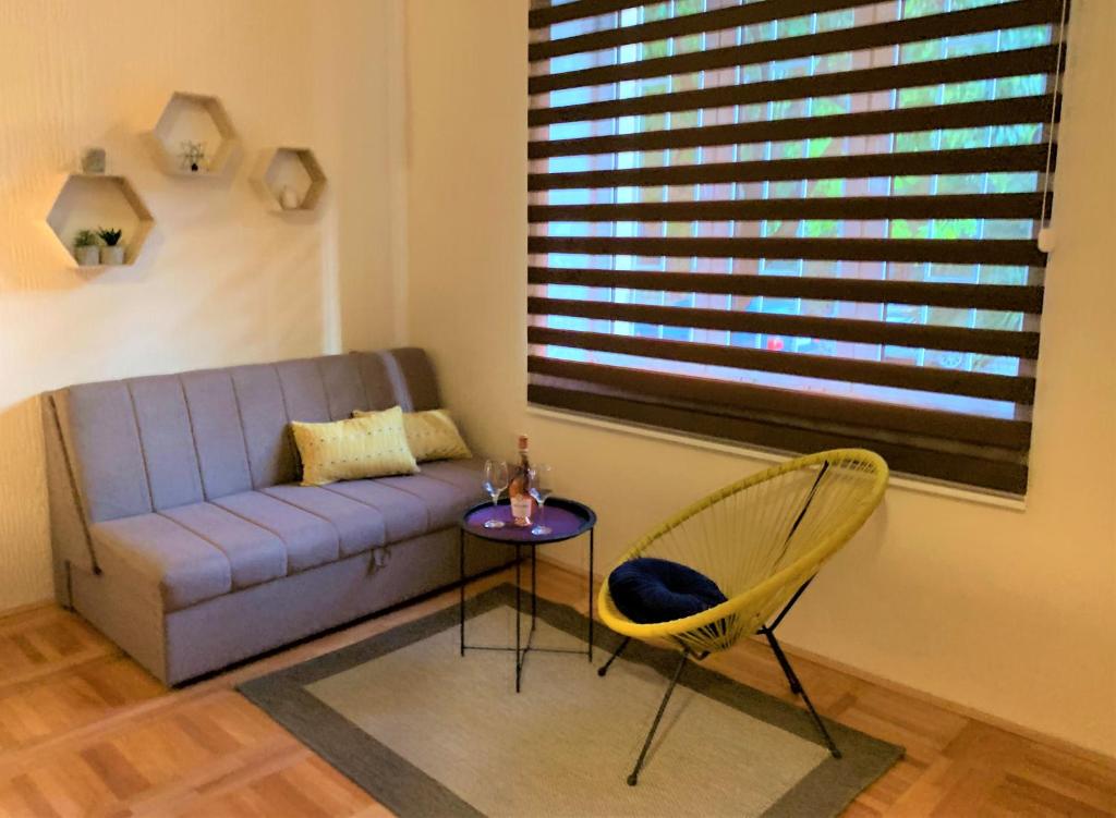 a living room with a couch and a table and a chair at Cicki Apartments II in Podgorica