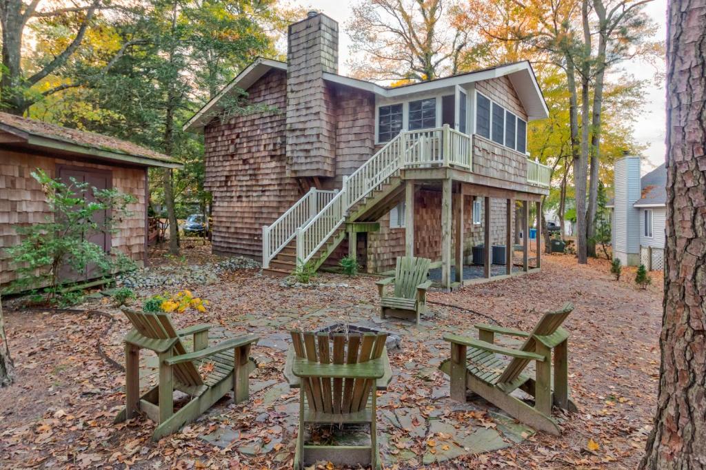 une maison avec une terrasse couverte et 2 chaises dans la cour dans l'établissement Home Away From Home, à Ocean Pines