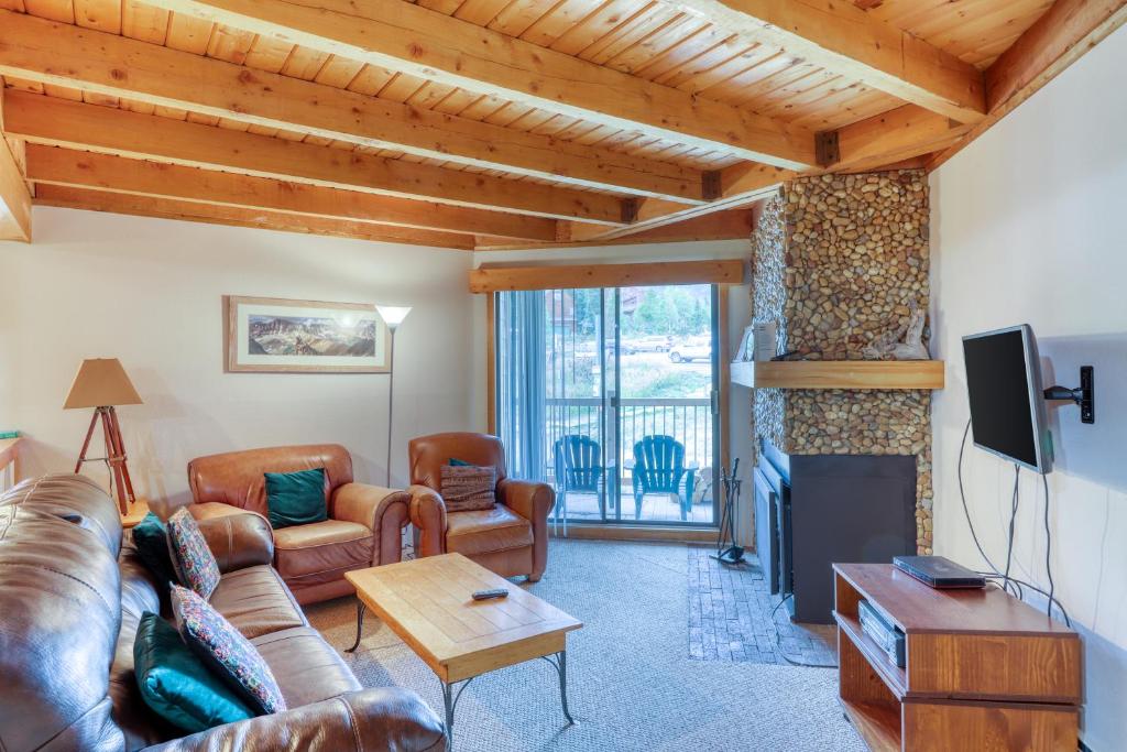 a living room with a couch and a tv at Treehouse 206F in Silverthorne
