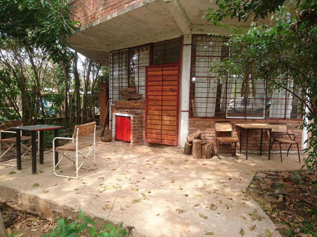 una casa con porta rossa, sedie e tavolo di Scenario Yguazu a Puerto Iguazú