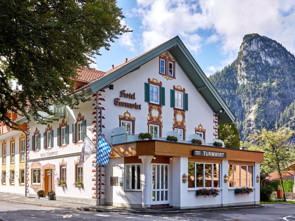 a building in front of a mountain at AKZENT Hotel Turmwirt ***S in Oberammergau