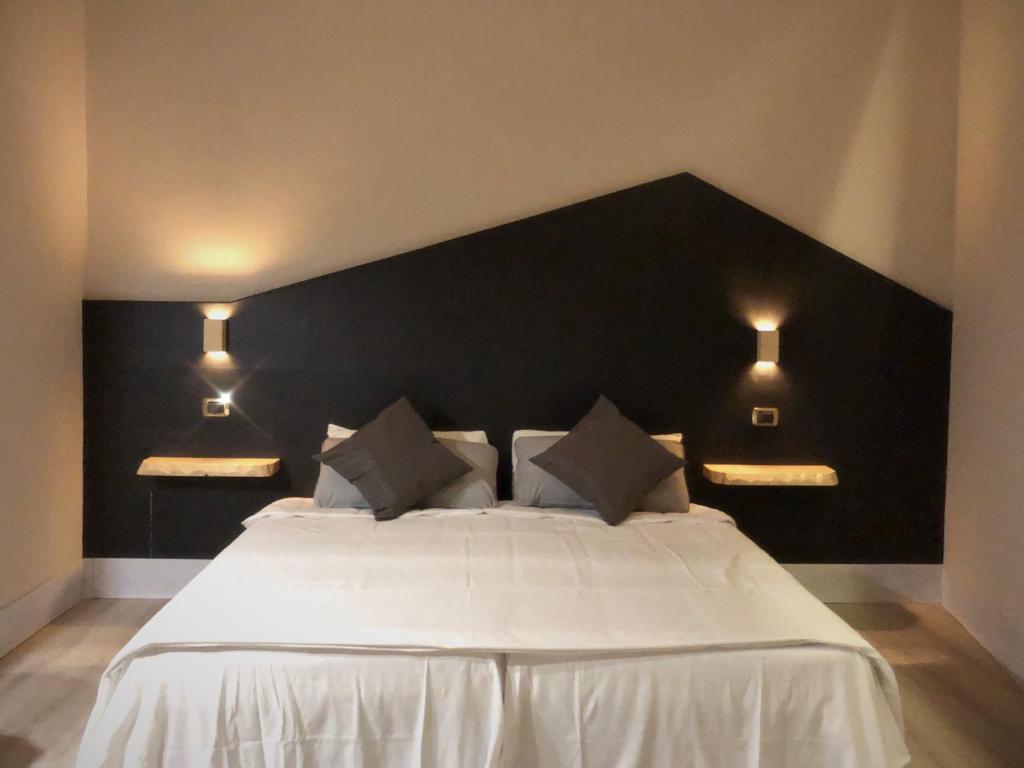 a bedroom with a white bed with a black headboard at Hotel Paris in Rome