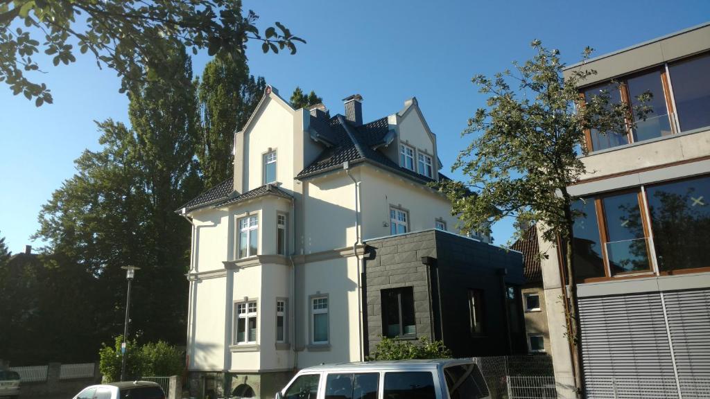 a white house with a car parked in front of it at Kissinger in Detmold