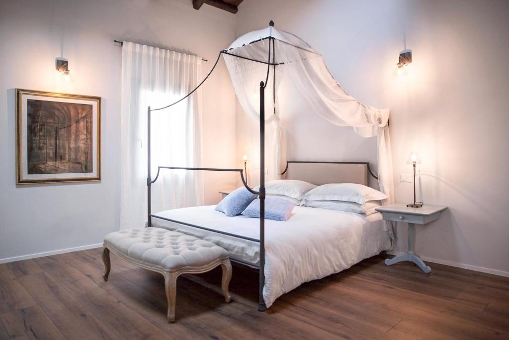 sypialnia z łóżkiem z baldachimem i stołkiem w obiekcie Ca' Ciaran w mieście Chiarano
