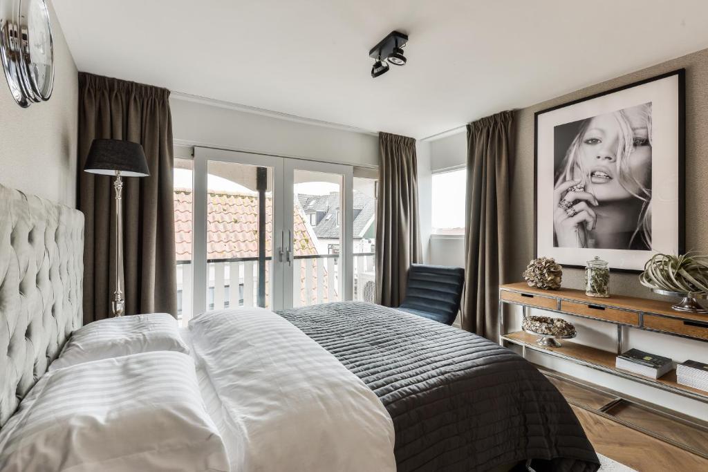 a bedroom with a large bed and a balcony at Boutique hotel The Old Bridge, Volendam in Volendam