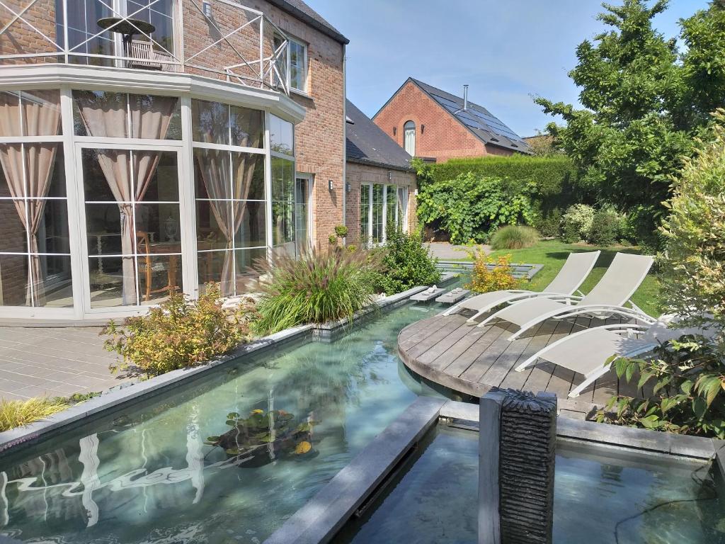 a swimming pool in the backyard of a house at Le Mont Saint Roch , chambre d'hôtes, B&B in Nivelles