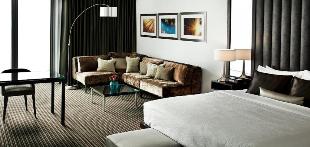 a bedroom with a bed and a couch and a table at The Lumen in Dallas