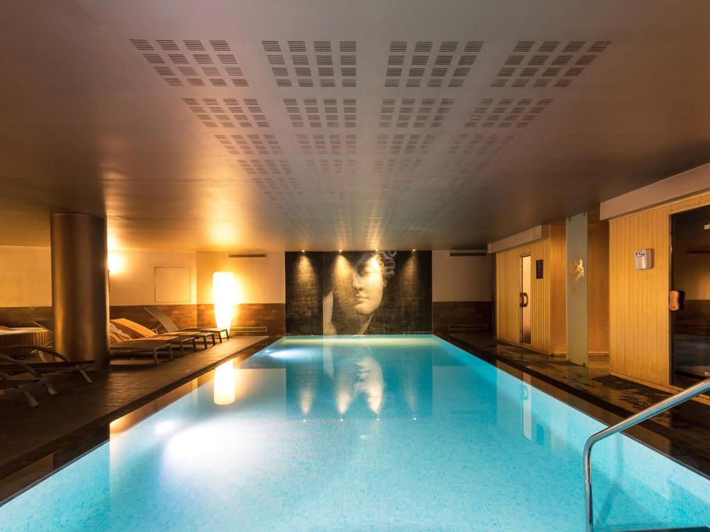 una piscina en un hotel con gente de pie en él en Dom Pedro Lisboa, en Lisboa