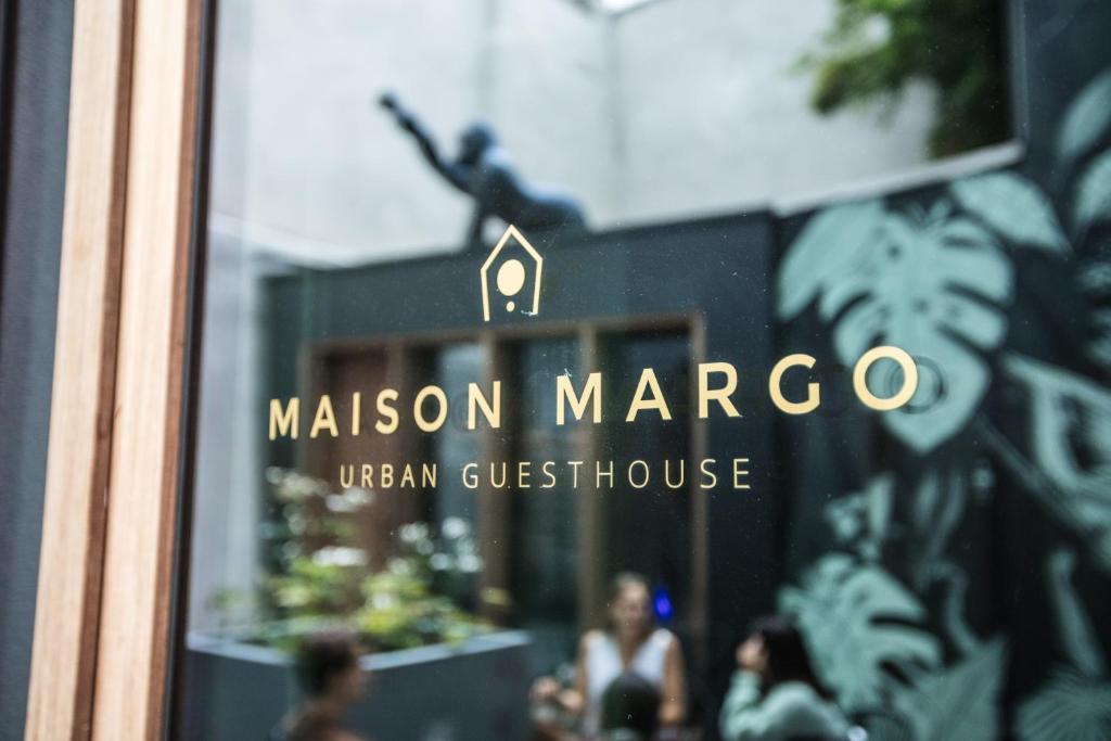 una señal en el lateral de una ventana de cristal de un restaurante en Maison Margo, en Gante