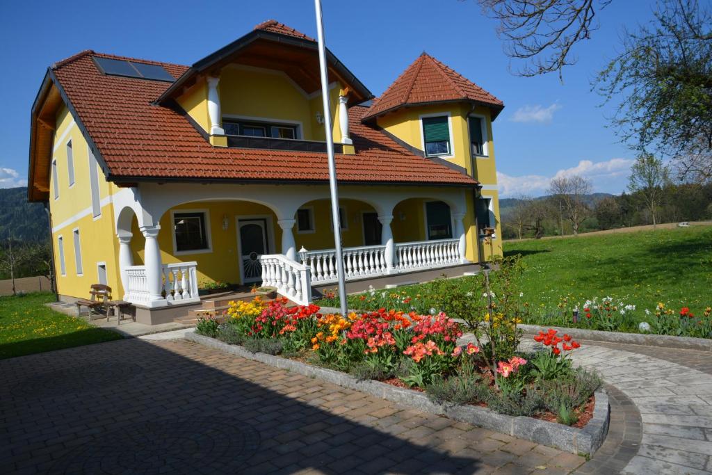 弗克馬克特的住宿－Privatzimmer Marina，前面有鲜花的黄色房子