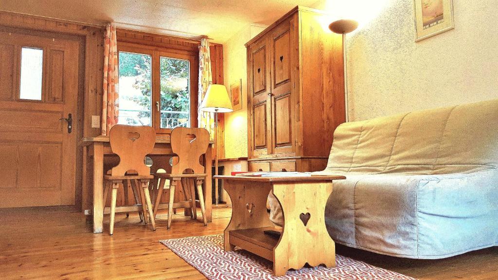 un soggiorno con un divano e un tavolo di Le Petit Chalet - 5' zum Skilift - kostenlose Getränke a Ovronnaz