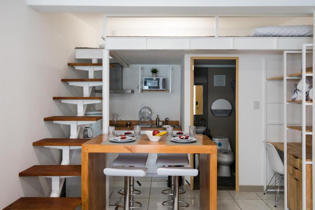 a small kitchen and dining room with a loft bed at Apartments and Rooms Distecon in Guatemala