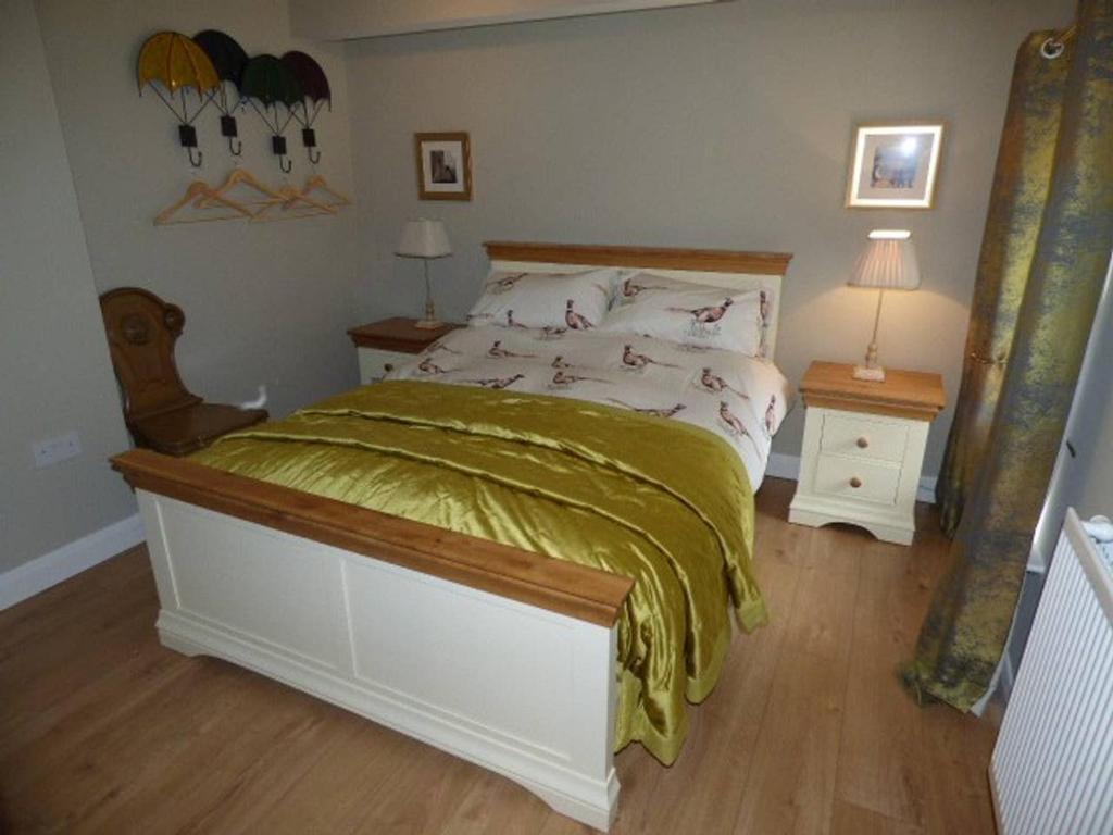een slaapkamer met een groot bed en een groene deken bij No6 @ Globe Lane,Alston in Alston