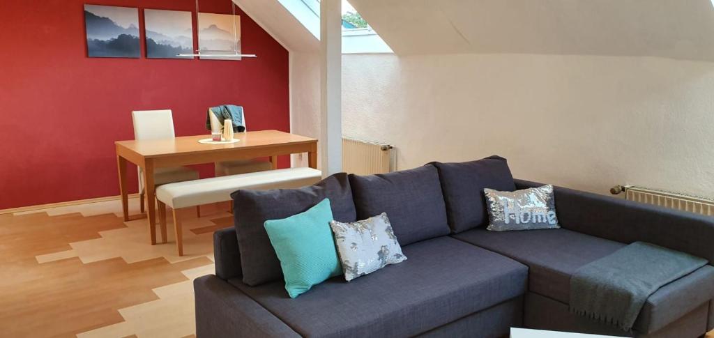 ein Wohnzimmer mit einem blauen Sofa und einem Tisch in der Unterkunft Ferienwohnung Leo Duisburg - Nähe Bahnhof in Duisburg