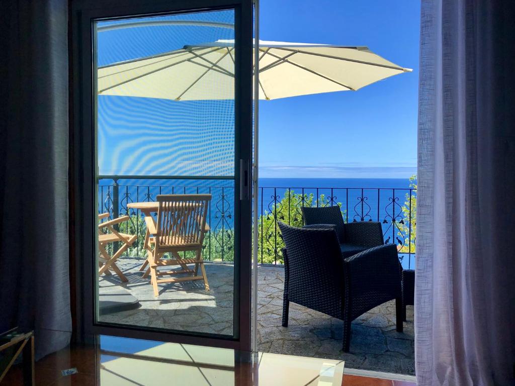 a view of a patio with a table and an umbrella at La VIGIE de CASTELROCK ( Casa Petunia ) in Mosteiros