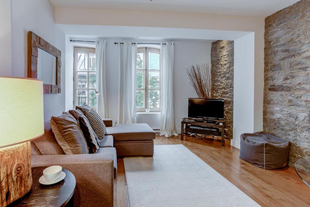 a living room with a couch and a tv at Les Immeubles Charlevoix - Le 1173 in Quebec City