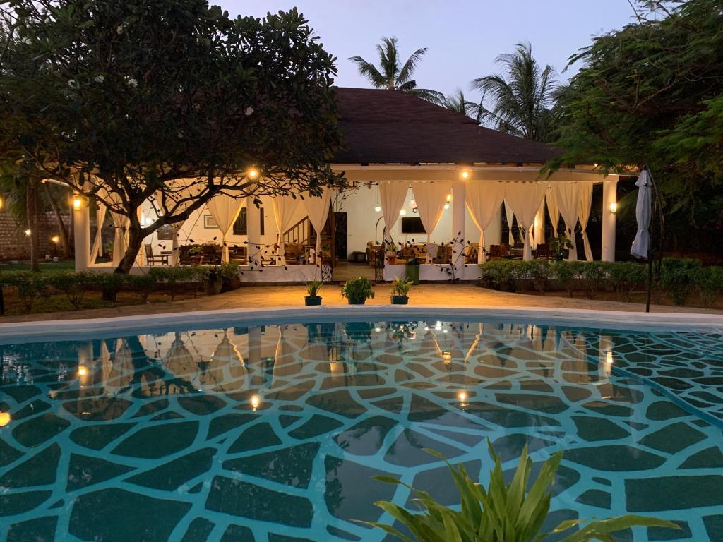 a swimming pool in front of a building at Villa Ameera Malindi in Malindi