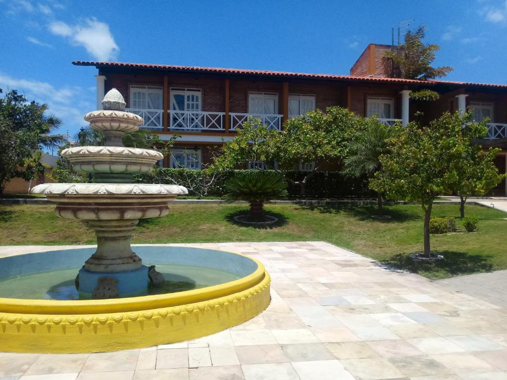 una fuente frente a una casa con un edificio en Hotel Porto Belo, en Aquiraz