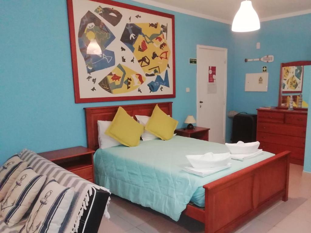 ポルティマンにあるAncora T0 Apartamento Praia da Rochaのベッドルーム1室(黄色と青の壁のベッド1台付)