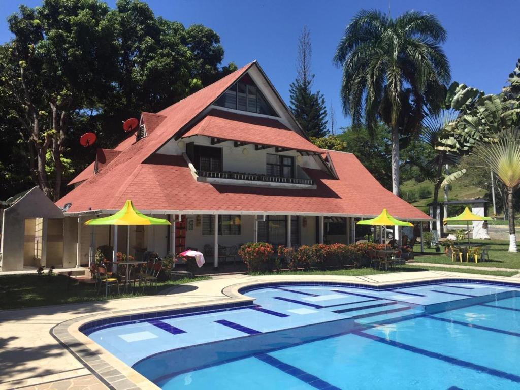 a resort with a swimming pool and a building at Finca Hotel Pinares in La Pintada
