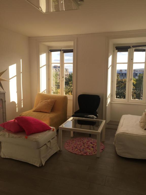 a living room with a couch and a table and windows at Le Jardin Darcy Liberté Hyper centre gare-ville parking public payant dans la rue in Dijon