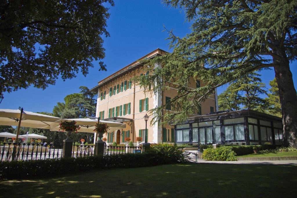 ein Gebäude mit einem Zaun vor einem Hof in der Unterkunft Hotel Villa Verdefiore in Appignano