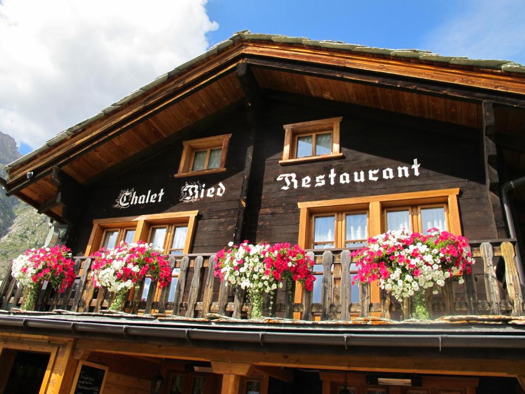 a wooden building with flowers on a balcony at Matterhorn Ried Suite in Zermatt